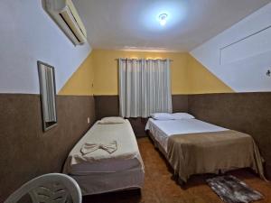 a bedroom with two beds and a window at Pousada SolMaris in João Pessoa