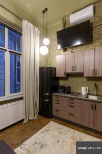 a kitchen with a black refrigerator and a window at Апарат готель під ЗОЛОТИМ КОРАБЛЕМ двохрівнева студія in Chernivtsi