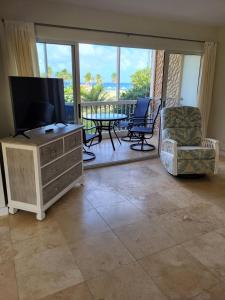 a living room with a television and a balcony at The Flip Flop Villa in Christiansted