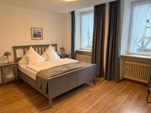 a bedroom with a bed and two windows at RATSKELLER Hotel & Restaurant in Kröv