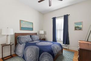 a bedroom with a bed with a blue comforter at Modern West End Townhome 3BR 2BA in Portland