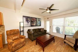 a living room with a couch and chairs and a ceiling fan at Captain Jacks Pearl in Port Aransas
