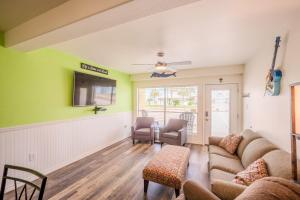 a living room with a couch and a tv at Five O Clock Somewhere in Port Aransas