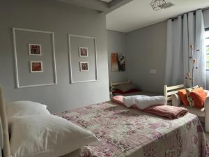 a bedroom with a bed with a blanket and a window at Pousada Luar in Chapada dos Guimarães