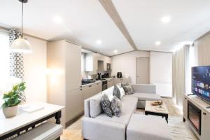 a living room with a couch and a tv at The Forest Lodge, Glen Eagles. in Auchterarder