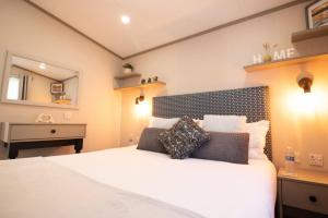 a bedroom with a large white bed and a sink at The Forest Lodge, Glen Eagles. in Auchterarder