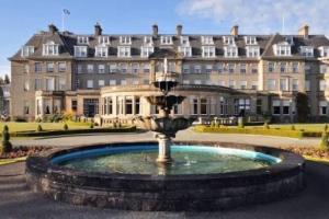 a fountain in front of a large building at The Forest Lodge, Glen Eagles. in Auchterarder