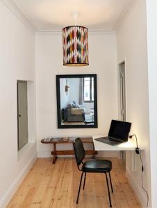 a living room with a desk with a laptop on it at Chez flader, deux pièces de 55m2 centre historique in Langeac