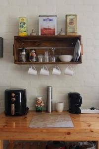 a kitchen counter with a wooden table with cups at Cozy and Central Bachelor Flat in Wellington