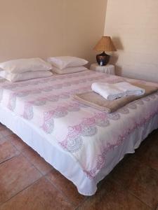 a large bed with a pink and white blanket at Cozy and Central Bachelor Flat in Wellington