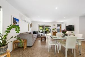 a living room with a couch and a table at Lucis Beach Retreat in Coolum Beach