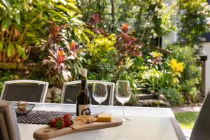a bottle of wine and two glasses on a table at Lucis Beach Retreat in Coolum Beach