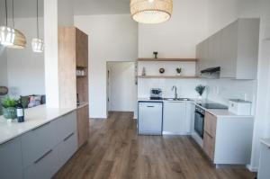 a kitchen with white appliances and wooden floors at NamibStay Swakop Self Catering in Swakopmund