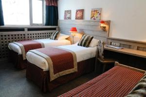 Voodi või voodid majutusasutuse Hôtel Arcadien toas