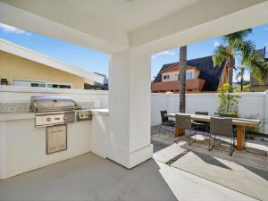 a patio with a grill and a table on a balcony at Outrigger Beach Retreat in Oxnard