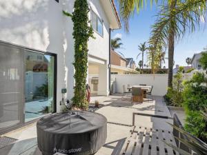 a patio with a table and benches in a house at Outrigger Beach Retreat in Oxnard