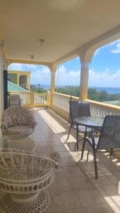 a patio with a table and chairs on a balcony at Pacific View Apartment in Roseau