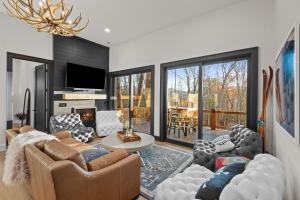 a living room with a couch and chairs and a tv at Highland House in Banner Elk