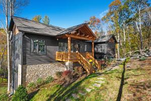 a log home with a porch and a deck at Highland House in Banner Elk