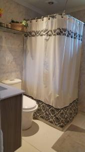 a bathroom with a shower curtain and a toilet at Casa Refugio Relajante in Pirque +35 photos