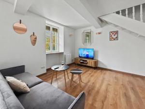 a living room with a couch and a tv at Le Duplex in Valence +3 photos