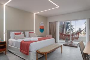 a white bedroom with a large bed and a window at Japaratinga Lounge Resort - All Inclusive in Japaratinga