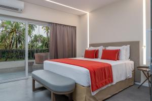 a bedroom with a large bed with red pillows at Japaratinga Lounge Resort - All Inclusive in Japaratinga