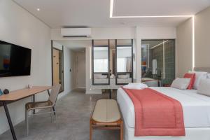 a hotel room with a bed and a desk and a desk at Japaratinga Lounge Resort - All Inclusive in Japaratinga
