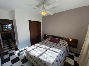 a bedroom with a bed and a ceiling fan at La Tonja in Pinamar