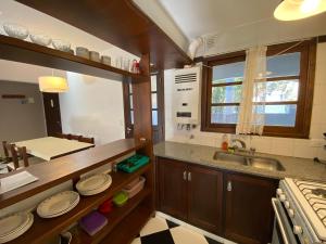 a kitchen with a sink and a counter with plates on it at La Tonja in Pinamar