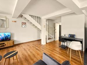 an empty living room with a desk and a staircase at Le Duplex in Valence
