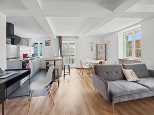 a living room with a couch and a kitchen at Le Duplex in Valence