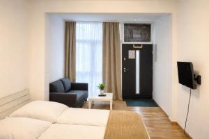 a room with a bed and a couch and a window at baadenbergerstay A in Cologne