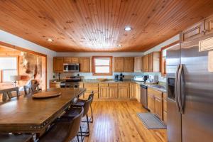 a kitchen with wooden cabinets and a large wooden table at Rosey Outlook in Boone