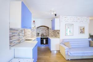 a kitchen with blue and white cabinets and a couch at Ca da maina in Riomaggiore