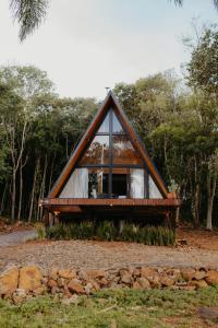 a frame house with a window in the forest at Canaã Cabanas in Mariópolis +23 photos