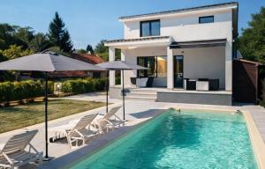 a house with a swimming pool with chairs and umbrellas at Villa Kally Fruska Gora in Velika Remeta