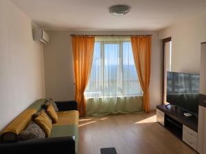 a living room with a couch and a large window at Изгрев-Бяла in Byala