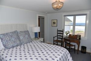 a bedroom with a bed and a table with a desk at Nautilus Beach House in Kennebunk