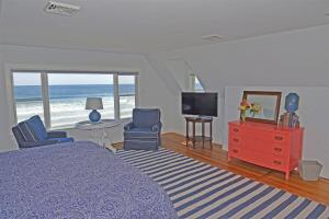 a bedroom with a bed and a television and the beach at Nautilus Beach House in Kennebunk