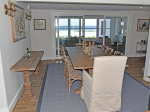 a dining room with a wooden table and chairs at Nautilus Beach House in Kennebunk