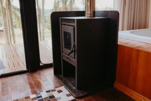 a fireplace in a living room with a tv at Canaã Cabanas in Mariópolis