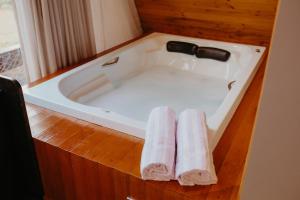 a bath tub with two towels sitting in it at Canaã Cabanas in Mariópolis