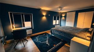 a bedroom with blue walls and a bed and a rug at GT Nord Hof in Müllenbach