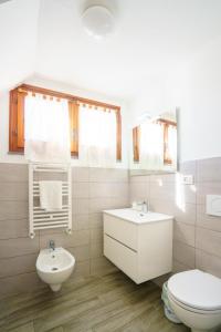 a white bathroom with a toilet and a sink at Ca da maina in Riomaggiore +19 photos