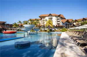 a pool at a resort with chairs and a building at Recanto Cataratas - Thermas, Resort e Convention in Foz do Iguaçu
