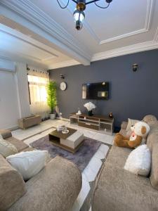 a living room with two couches and a table at VVVIP lita Résidence in Ekoumdoum