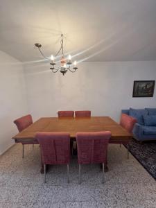 a dining room table with chairs and a chandelier at צימר הר הגמל in Mitzpe Ramon