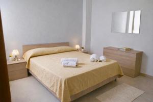 a bedroom with a bed with two towels on it at My Home Lampedusa in Lampedusa +3 photos