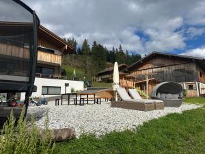 a patio with a bunch of chairs and an umbrella at Oberegghof in Wagrain